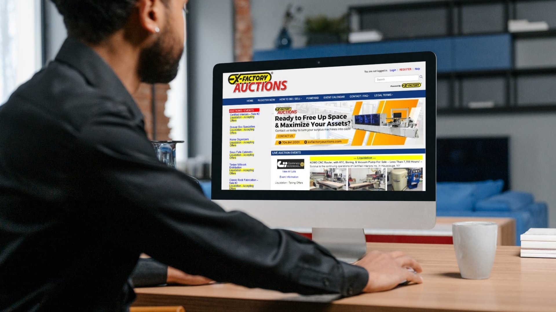 Man sitting at laptop making a bid on used equipment on the exfactory auctions website